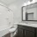 bathroom with dark cabinets and a mirror